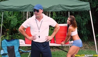 Сцена на летнем футбольном лагере: девушка и тренер.